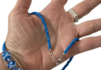 a hand holding a beaded necklace