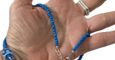 a hand holding a beaded necklace
