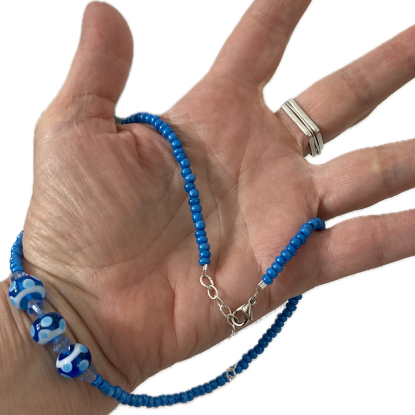 a hand holding a beaded necklace