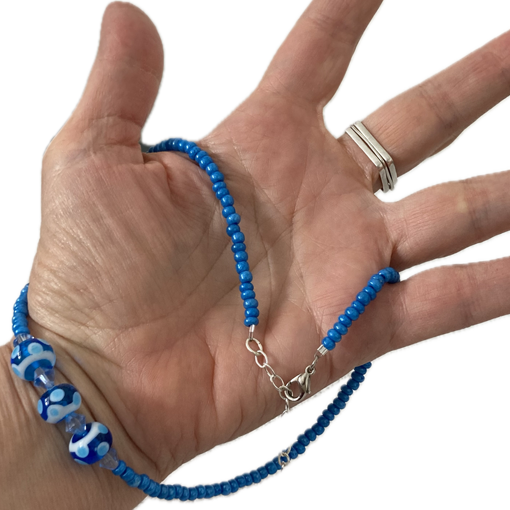 a hand holding a beaded necklace