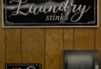 a sign on a laundry wall stinky washing machine fix