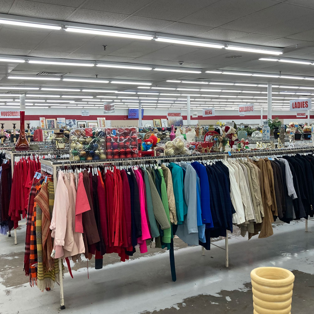 an organized thrift store with clothes on hangers