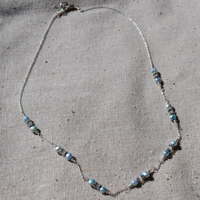 a sterling silver necklace with pearls on it