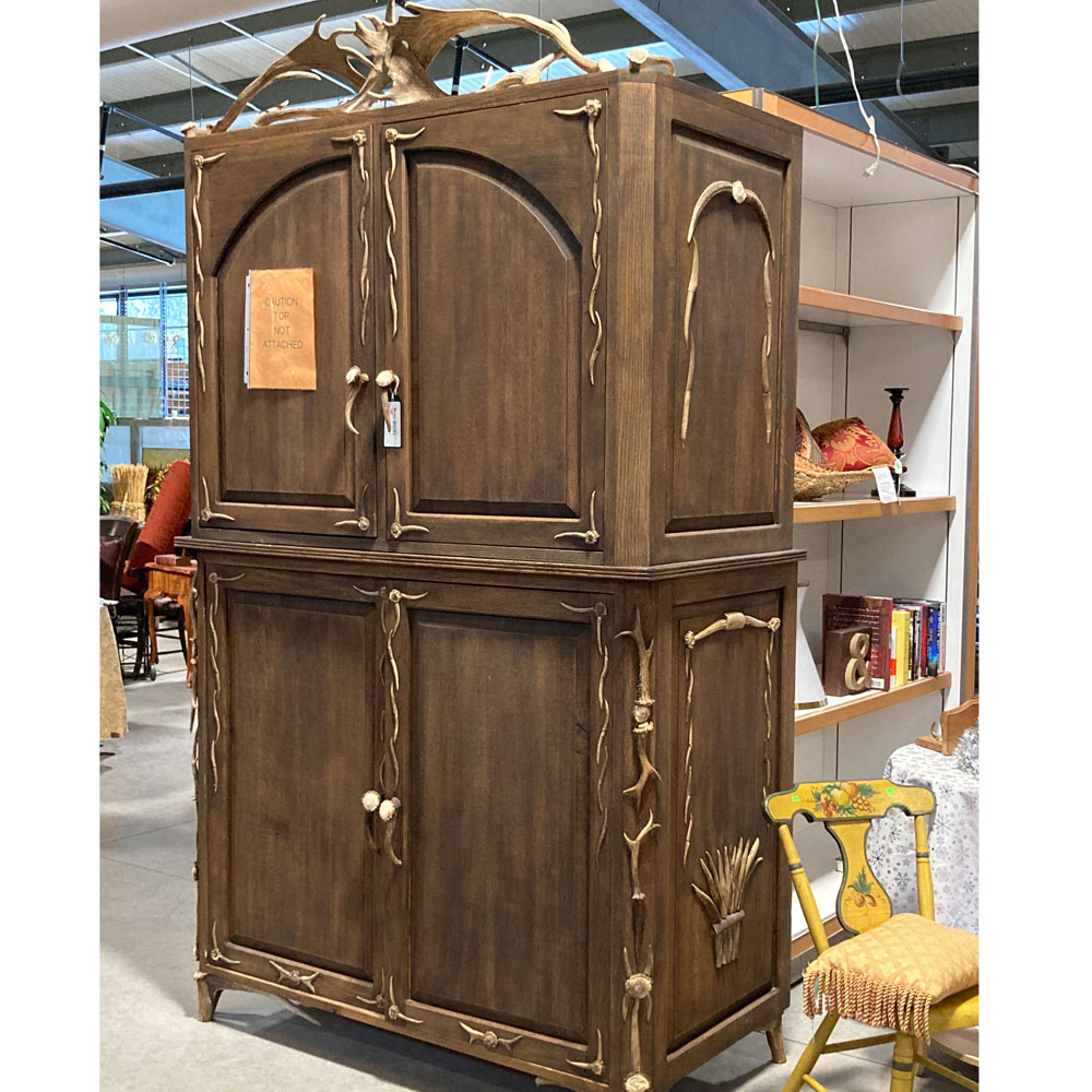 very large wooden cabinet decorated with real antlers