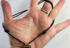 a hand with a sliding knot necklace