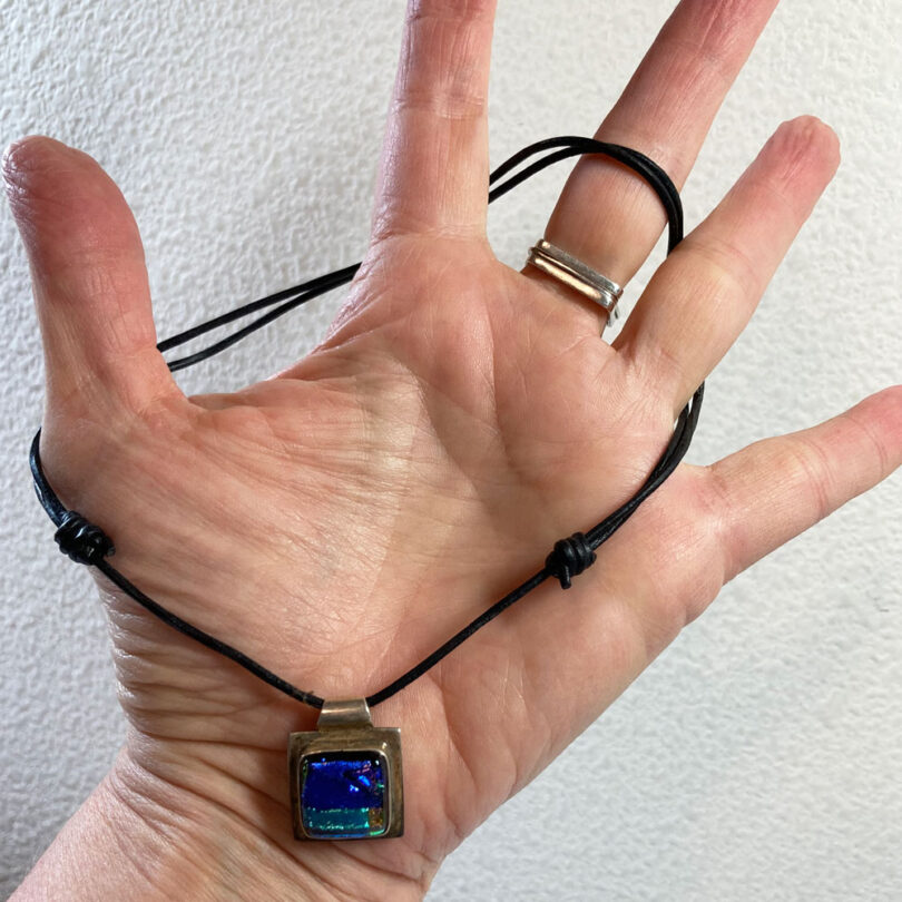 a hand with a sliding knot necklace