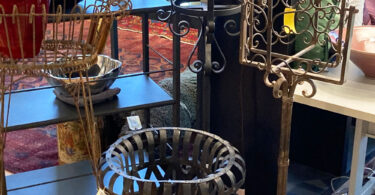 collection of metal furniture and decor in a thrift shop