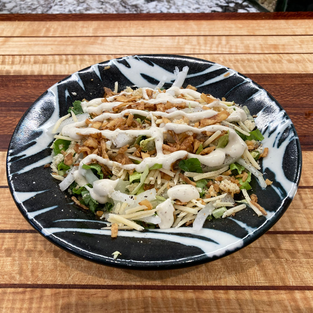 a plate of salad on a wood cutting board