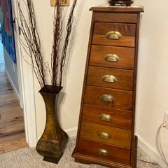 tall vase with branches and cabinet of drawers
